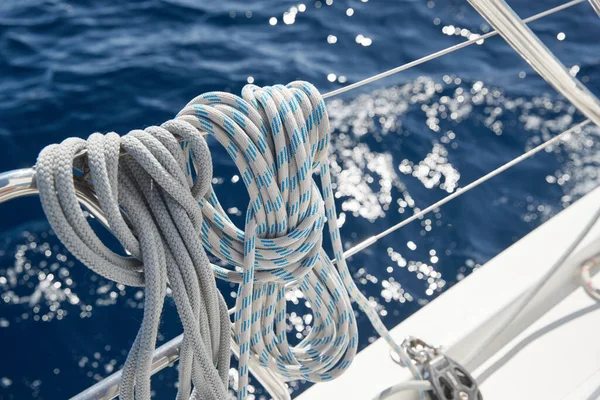 Close-up view of sailboat ropes at sunny weather, pulleys and ropes on the mast, Yachting sport, ship equipment, sea is on background Stock Image