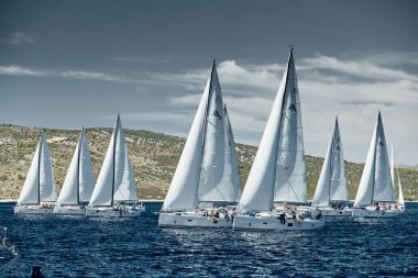 Hırvatistan, Adriyatik Denizi, 18 Eylül 2019: Yelkenliler yelkenli yarışı, yelkenli yarışı, sudaki yelkenlilerin yansıması, kıç teknelerinde tekne sayısı, arka planda ada, açık hava koşulları