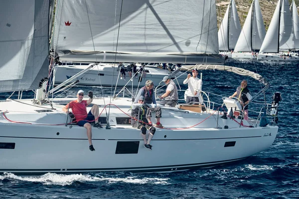 Croatia, Mediterranean Sea, 18 September 2019: The team of sailboat turns off the boat, sailboats compete in a sail regatta, The team works, pulls to a rope, a steering wheel, multicolored spinnakers — Stock Photo, Image