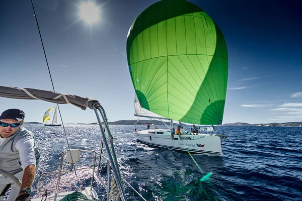 Croacia, Mar Mediterráneo, 18 Septiembre 2019: El equipo de veleros apaga el barco, veleros compiten en una regata de vela, El equipo trabaja, tira de una cuerda, un volante, spinnakers multicolores — Foto de Stock