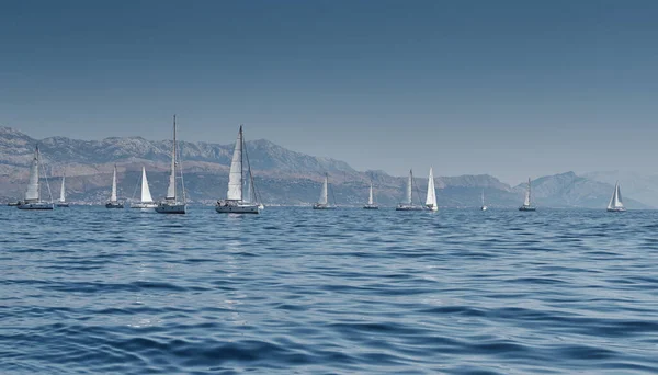 セーリングボートと美しい海の風景、水平線のヨットのレース、レガッタ、激しい競争、明るい色、風車のある島が背景にあります — ストック写真