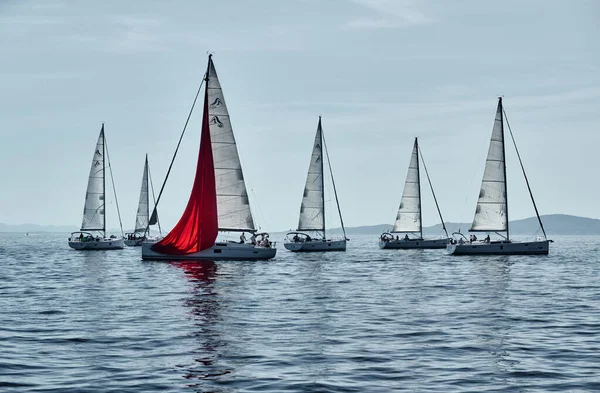 クロアチア、アドリア海、 2019年9月15日:ヨットレース、レガッタ、水上帆の反射、激しい競争、明るい色、風車のある島が背景にあります — ストック写真