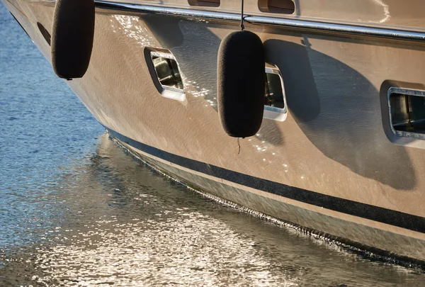 Raad van bestuur van de grote boot van gouden kleur, gouden reflecties van de zon op het water bij zonsondergang, interessante textuur, gladde lijnen van water — Stockfoto