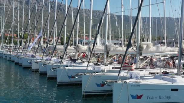 Croatia, Split, 15 September 2019: Brutal participant of a sailing regatta with boats on a background goes by bicycle on a pier, people is waiting for the forthcoming race, skipers and sailors — Stock Video