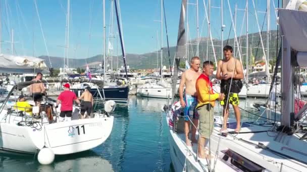 Croácia, marina Kastela, 15 de setembro de 2019: Participante de uma regata à vela com barcos em fundo, o barco sai do porto, as pessoas estão esperando a próxima corrida, esquiadores e marinheiros — Vídeo de Stock