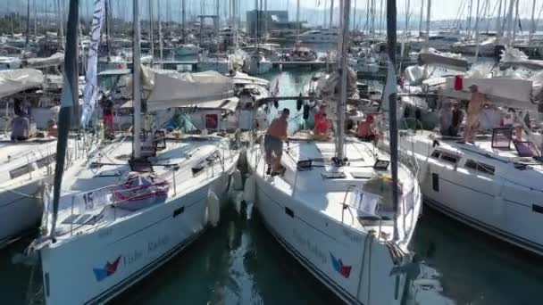 Kroatië, jachthaven Kastela, 15 september 2019: Deelnemer aan een zeilregatta met boten op de achtergrond, een pier, mensen wachten op de komende race, skiërs en zeilers — Stockvideo