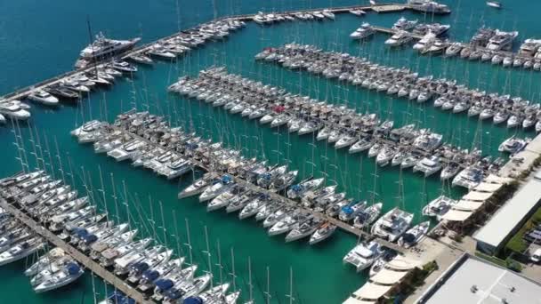 クロアチア,マリーナ・カステラ, 2019年9月15日:等しい行の帆船で係留されたドローンの視点、セーリングレガッタの参加者、桟橋、多くのボート、山が背景にあります — ストック動画