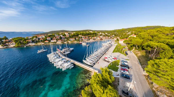 Croacia, Maslinica, 15 de septiembre de 2019: Punto de vista del dron amarrado en una fila igual veleros al atardecer, participante de una regata de vela, la gente descansa después del día de carreras, agua azul, muelle — Foto de Stock