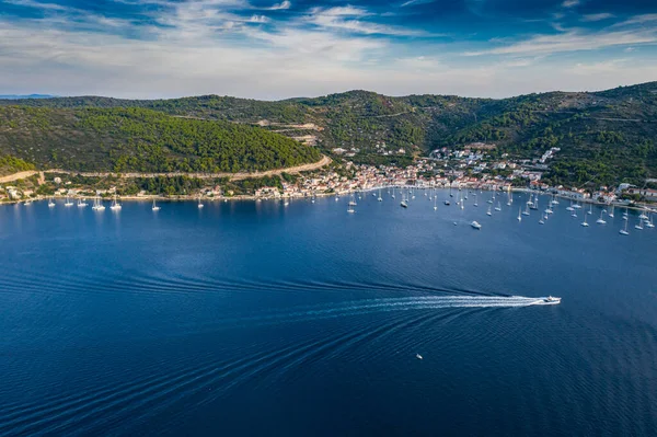 Vista aérea da marina Vis ao pôr-do-sol, Croácia, um monte de barcos de pé caoticamente em uma baía, telhados de cor laranja, sol, colinas com árvores verdes, estação de balsa — Fotografia de Stock
