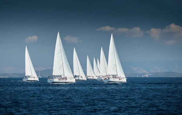 Das Rennen der Segelboote, eine Segelregatta, Reflexion der Segel auf dem Wasser, Intensiver Wettbewerb, Anzahl der Boote auf Achterbooten, Helle Farben, Insel ist auf dem Hintergrund — Stockfoto