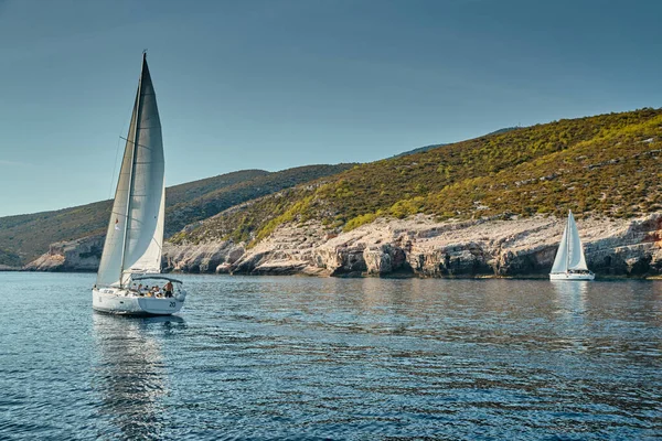 A corrida de veleiros, uma regata vela, reflexo de velas na água, Competição intensa, número de barco está em barcos de popa, cores brilhantes, ilha está no fundo — Fotografia de Stock