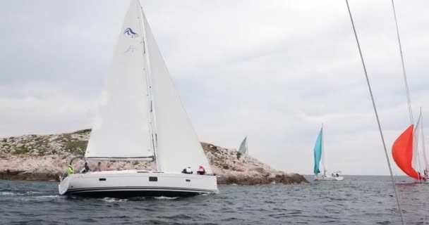 Horvátország, Adriai-tenger, 19 Szeptember 2019: A verseny a vitorlások, a csapat ül a szélén egy hajó fórumon, csapatmunka, intenzív harc, élénk színek, más résztvevők a verseny a háttérben — Stock videók