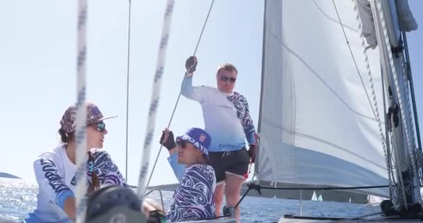 Kroatien, Adria, 19. September 2019: Das Rennen der Segelboote, Segler drehen die Winde, ziehen ein Seil, Teamarbeit, intensiver Kampf, helle Farben, andere Teilnehmer des Rennens auf einem Hintergrund — Stockvideo