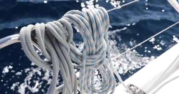 Vista de cerca de las cuerdas de velero en el clima soleado, poleas y cuerdas en el mástil, Deportes náuticos, equipo de barco, el mar está en el fondo — Vídeo de stock