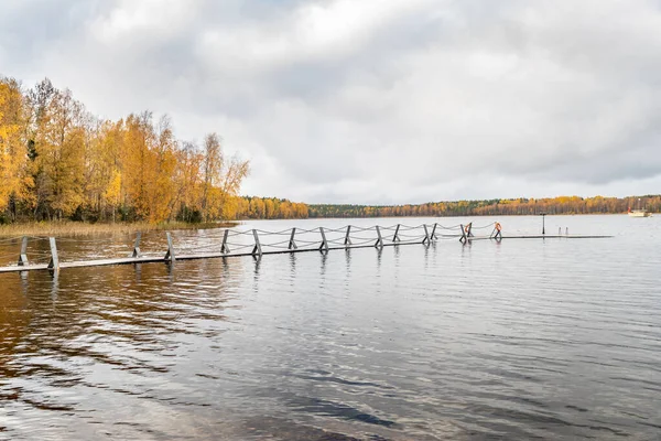 La jetée longue sur le lac, Terrasse au lac, L'automne au lac Boroye, Bateaux à une jetée, Parc national du Valday, Russie, image panoramique, arbres dorés, Lodges en bois, temps nuageux — Photo