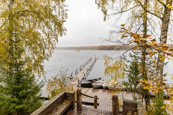 La jetée longue sur le lac, Terrasse au lac, L'automne au lac Boroye, Bateaux à une jetée, Parc national du Valday, Russie, image panoramique, arbres dorés, Lodges en bois, temps nuageux — Photo