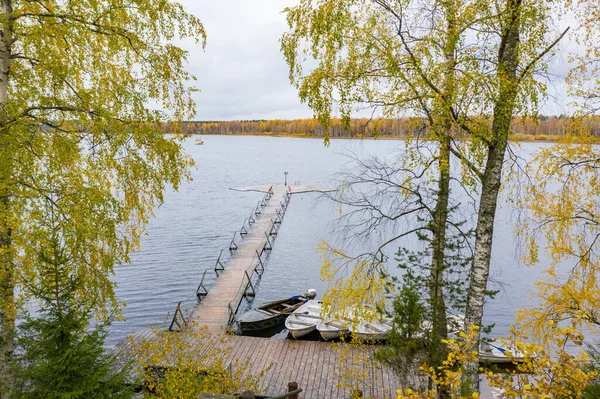 La jetée longue sur le lac, Terrasse au lac, L'automne au lac Boroye, Bateaux à une jetée, Parc national du Valday, Russie, image panoramique, arbres dorés, Lodges en bois, temps nuageux — Photo