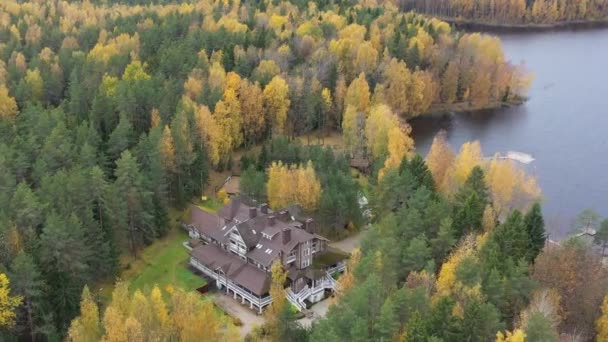 Drone kilátás pont a vidéki terület ősszel tó Boroye, A nagy faház az erdőben, Piers a tavon, Valday nemzeti park, Oroszország, panoráma kép, aranyfák, Faházak, felhős időjárás — Stock videók