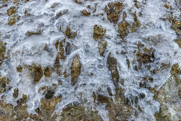 El agua helada que fluye hacia abajo en la ladera de la montaña, el glaciar sobre el dolor, el hielo sobre las rocas el deshielo primaveral del hielo —  Fotos de Stock