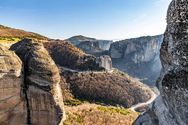 Aerial view of monastery Rousanou and breathtaking picturesque valley and landmark canyon of Meteora at sunset, Kalambaka, Greece, shadows, twisted road, bridge — Stock Photo, Image