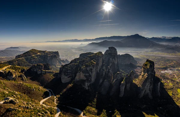 Vista aérea del monumento de la Unesco Meteora, las montañas, el punto de referencia de Grecia, tiempo soleado, niebla, neblina sobre un valle — Foto de Stock