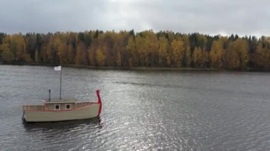 Rusya, Valday, 05 Ekim 2019: Göldeki ahşap tekne banyosu drone görüntüsü, Boroye Gölü, Valday Ulusal Parkı, Rusya, panoramik video, altın ağaçlar, bulutlu hava durumu