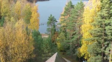Evden göle ve uzun iskeleye uçuş, göldeki teras, Boroye Gölü 'ndeki sonbahar, Valday Ulusal Parkı, Rusya, panoramik görüntü, altın ağaçlar, ahşap pansiyonlar, bulutlu hava