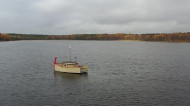 Rusya, Valday, 05 Ekim 2019: Göldeki ahşap tekne banyosu drone görüntüsü, Boroye Gölü, Valday Ulusal Parkı, Rusya, panoramik video, altın ağaçlar, bulutlu hava durumu