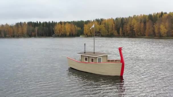 Drone vista de baño barco de madera en un lago, zona de agua en otoño con el lago Boroye, parque nacional de Valday, Rusia, video panorámico, árboles dorados, tiempo nublado — Vídeo de stock