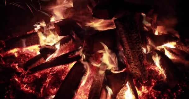 Close up video al rallentatore del grande fuoco con legna da ardere di notte, falò che brucia di notte, scintille, fiamme del fuoco, è un sacco di carboni rossi di legno, camino, vapore e fumo — Video Stock