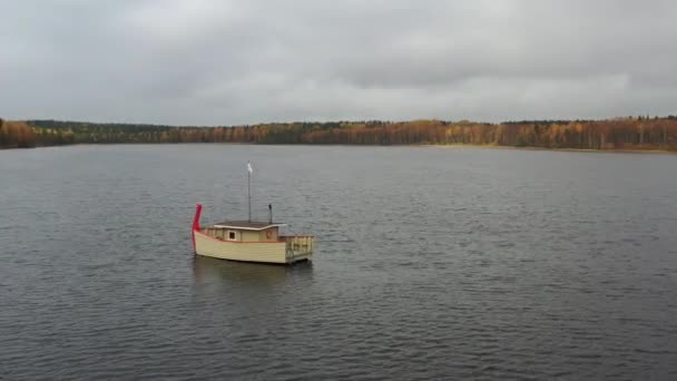 Ryssland, Valday, 05 oktober 2019: Drönare utsikt över träbåtsbadet på en sjö, vattenområde på hösten med sjön Boroye, Valday nationalpark, Ryssland, panorama video, gyllene träd, molnigt väder — Stockvideo