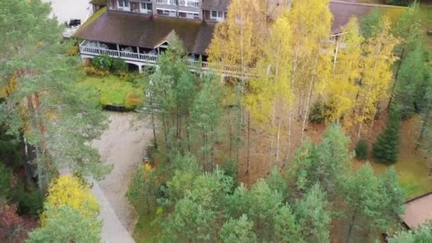 Ryssland, Valday, 05 oktober 2019: Flyg över huset, drönarutsikt över landsbygden på hösten med sjön Boroye, Det stora trähuset i skogen, Valdays nationalpark, gyllene träd — Stockvideo