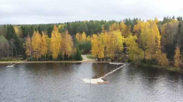 Den långa piren på sjön, terrass vid sjön, hösten vid sjön Boroye, Båtar vid en brygga, Valday nationalpark, Ryssland, panoramabild, gyllene träd, trä loger, molnigt väder — Stockvideo