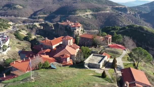 Kalambaka, Griechenland, Luftaufnahme des Klosters Varlaam und atemberaubende Bilder von Tal und Meteora-Schlucht bei Sonnenaufgang, Wiege an der Seilbahn, viele Touristen, rote Dächer des Klosters — Stockvideo