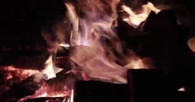  Gece yakacak odunlu büyük ateş, gece yanan şenlik ateşi, kıvılcımlar, ateşin alevleri, bir sürü kırmızı ahşap kömür, şömine, sessiz, buharsız ve dumansız ağır çekim video.
