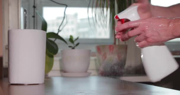 El hombre está limpiando las manos con desinfectante presionando el spray de botella, rollo de toallas de papel, desinfectando la piel de las manos durante la pandemia de coronavirus, epidemia de COVID-19. Lucha contra la propagación del virus — Vídeo de stock
