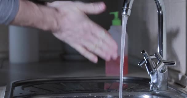 Homme se laver les mains sous l'eau avec un désinfectant en appuyant sur le gel bouteille et essuie les mains une serviette en papier, désinfecter la peau des mains pendant la pandémie de coronavirus, épidémie COVID-19, propagation du virus — Video