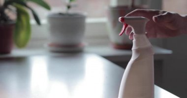 Adamın eli antiseptik spreyine basıyor, kağıt havluya serpiyor, kırmızı düğmeye basıyor, videoyu yavaş çekimde kapatıyor, Coronavirüs salgını sırasında deriyi dezenfekte ediyor, COVID-19 salgını sırasında elleri dezenfekte ediyor.