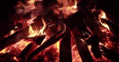  Gece yakacak odunlu büyük ateş, gece yanan şenlik ateşi, kıvılcımlar, ateşin alevleri, bir sürü kırmızı ahşap kömür, şömine, sessiz, buharsız ve dumansız ağır çekim video.