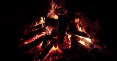  Gece yakacak odunlu büyük ateş, gece yanan şenlik ateşi, kıvılcımlar, ateşin alevleri, bir sürü kırmızı ahşap kömür, şömine, sessiz, buharsız ve dumansız ağır çekim video.