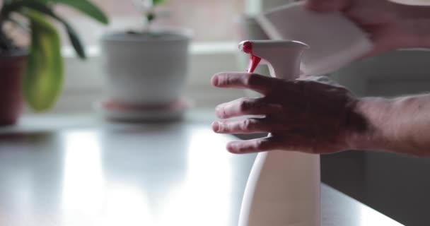 La mano del hombre presiona el aerosol antiséptico, espolvorea sobre una toalla de papel, presionando el botón rojo, video de cámara lenta, desinfectando la piel de las manos durante la pandemia de coronavirus, epidemia de COVID-19 — Vídeos de Stock