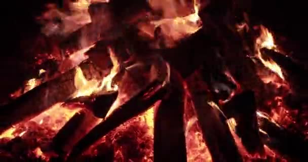  Le grand feu avec du bois de chauffage la nuit, feu de joie la nuit, étincelles, flammes du feu, est beaucoup de charbons de bois rouge, cheminée, vidéo ralenti sans son, vapeur et fumée 