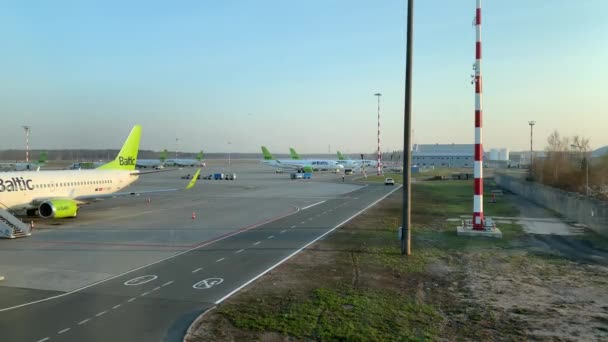 Λετονία, Ρίγα, 23 Απριλίου 2019: Θέα από το παράθυρο των αεροπλάνων κατά την υπηρεσία και την προετοιμασία της πτήσης στον τομέα του αεροδρομίου, Βενζινάδικο, υπηρεσίες καθαρισμού αεροπλάνων, ηλιόλουστος καιρός την άνοιξη — Αρχείο Βίντεο