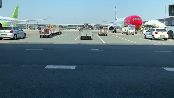 Latvia, Riga, 23 April 2019：View from window of aircraft on service and preparation for flight in the field of the airport, Gas station, cleaning plane services, sunny spring weather — 图库视频影像