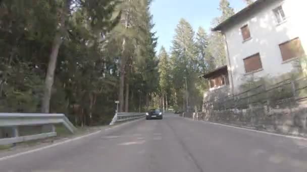 Италия, Альпы, 15 мая 2019 г.: Новый BMW Z4 M идет по асфальтированной дороге, зеленая долина среди гор, ясная солнечная погода, Видео впереди идущего автомобиля, высокая скорость, извилистая дорога, лес — стоковое видео