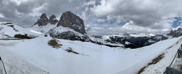 Vista panorámica de las montañas cubiertas de nieve Dolomitas en Italia en el día soleado, Canazei, la carretera retorcida, el cielo azul con nubes blancas, famoso lugar en el mundo, estación de esquí, monumento de la UNESCO — Foto de Stock