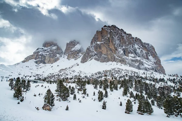 Luchtfoto van de Dolomieten besneeuwde bergen in Italië op zonnige dag, Canazei, skigebied, de gedraaide weg, de blauwe lucht met witte wolken, beroemde plek in de wereld, UNESCO monument — Stockfoto