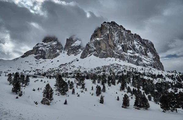 Luftaufnahme der schneebedeckten Dolomiten in Italien bei sonnigem Tag, Canazei, Skigebiet, die kurvenreiche Straße, der blaue Himmel mit weißen Wolken, berühmter Ort der Welt, UNESCO-Denkmal — Stockfoto