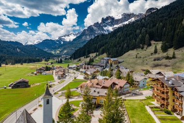 Chalet ile vadi manzarası, İtalya, Trentino, Fontanazzo dağlarının yeşil yamaçları, vadi üzerindeki devasa bulutlar, yerleşim yerlerinin çatıları, yeşil çayırlar, arka plandaki Dolomitler,