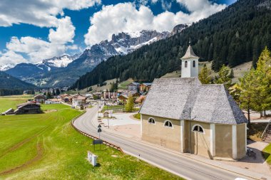 Chalet ile vadi manzarası, İtalya, Trentino, Fontanazzo dağlarının yeşil yamaçları, vadi üzerindeki devasa bulutlar, yerleşim yerlerinin çatıları, yeşil çayırlar, arka plandaki Dolomitler,